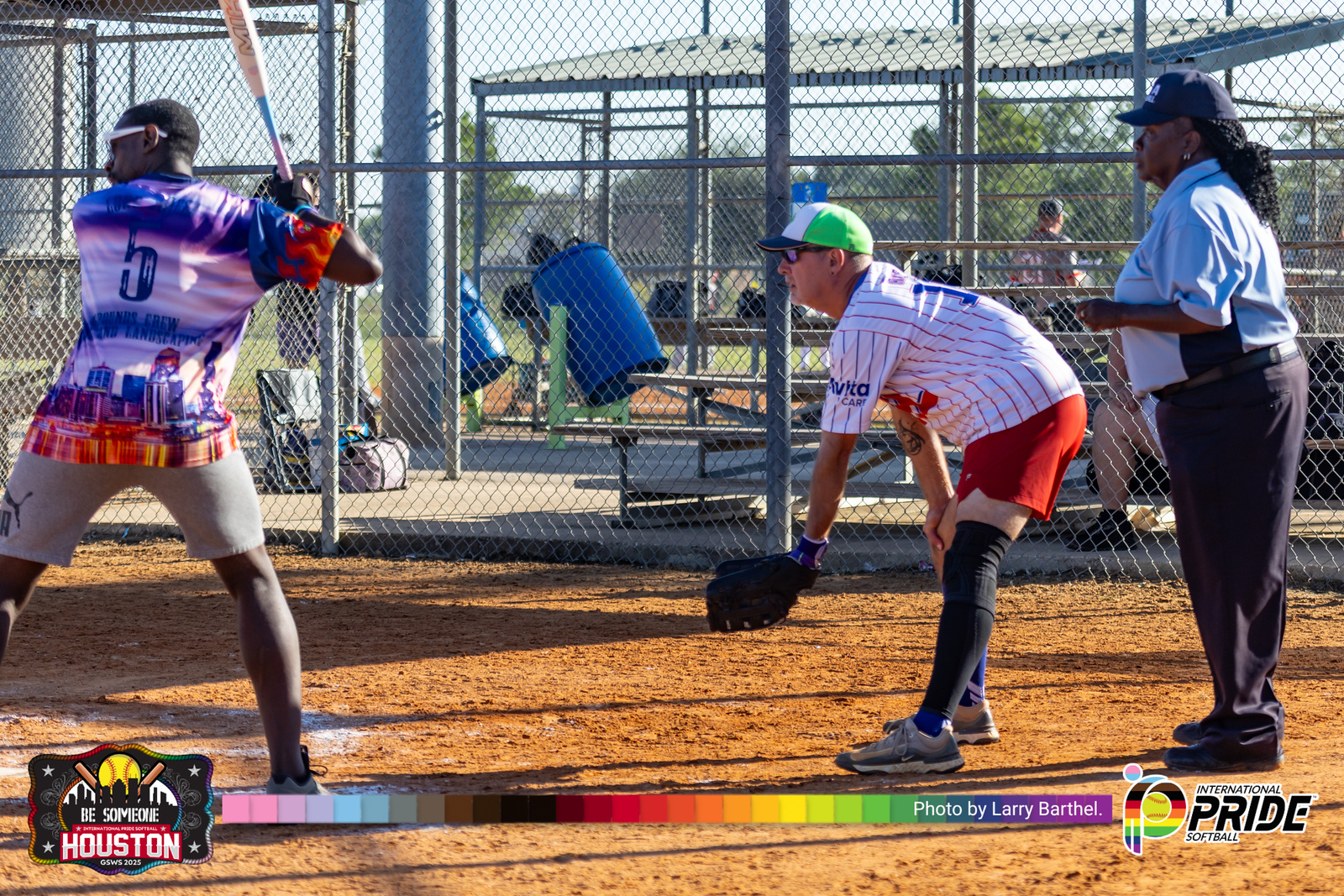 Diverse LGBTQIA2S+ softball players in action at home plate during an International Pride Softball tournament